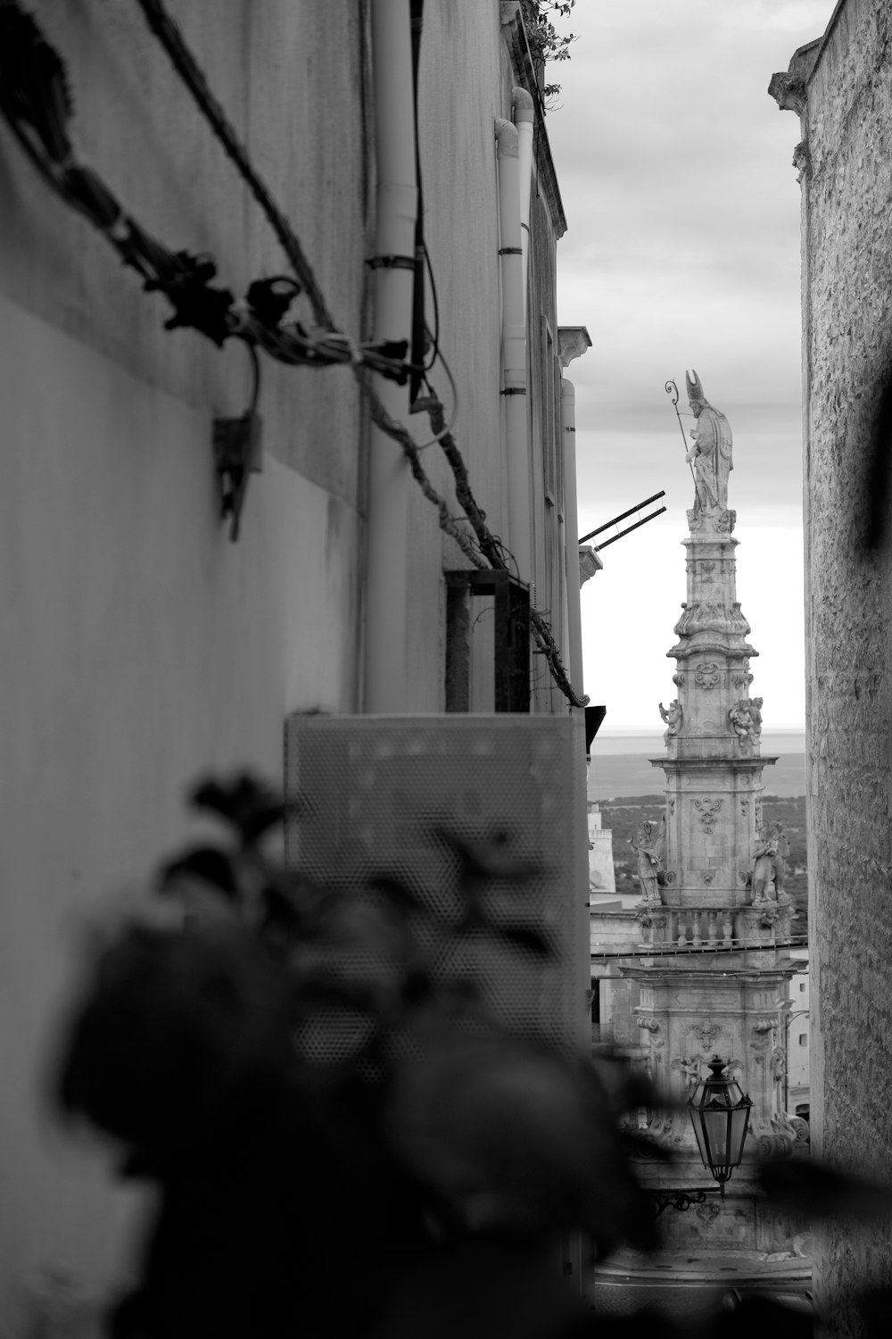 a black and white photo of a statue on a building