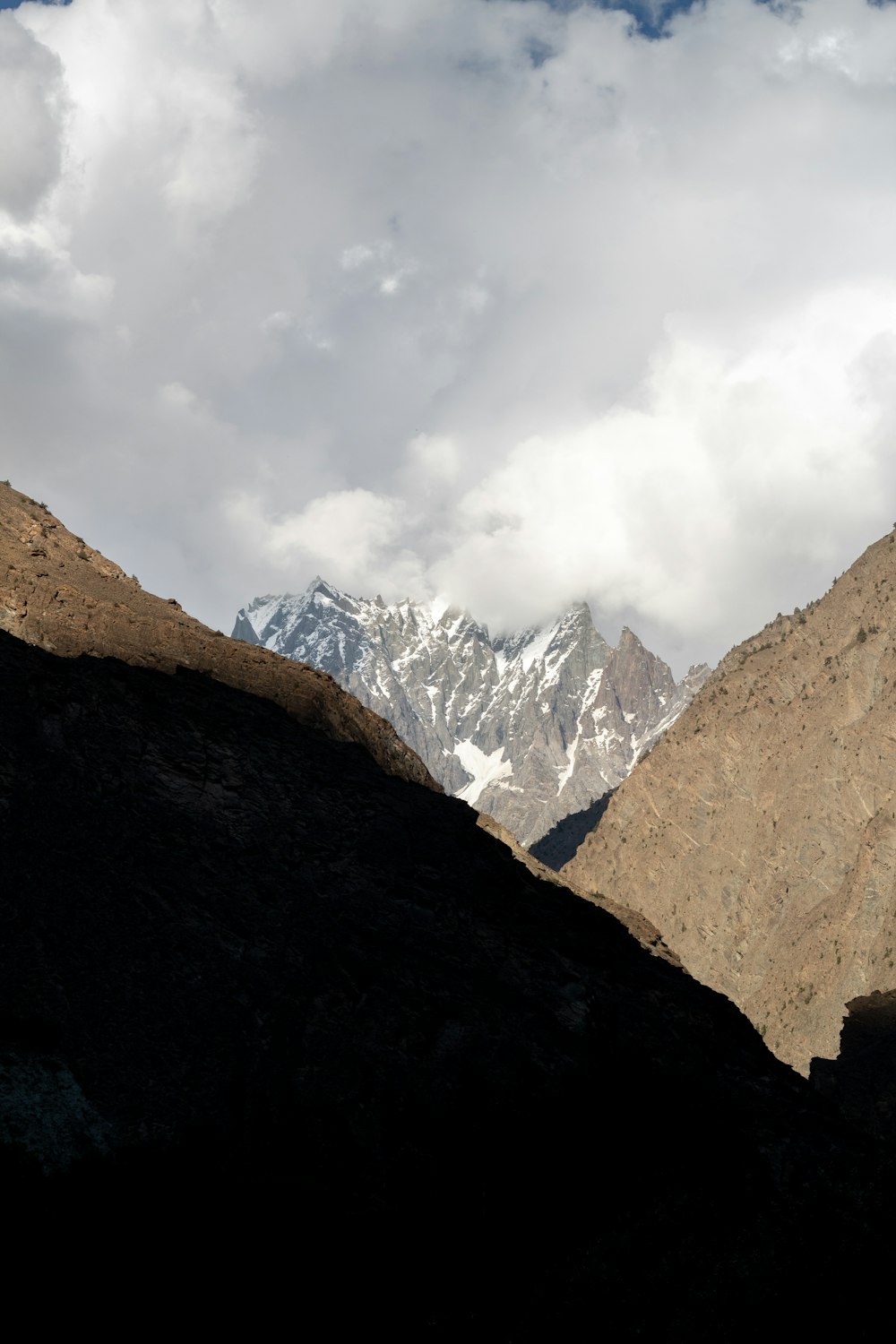 a view of a mountain range with clouds in the sky