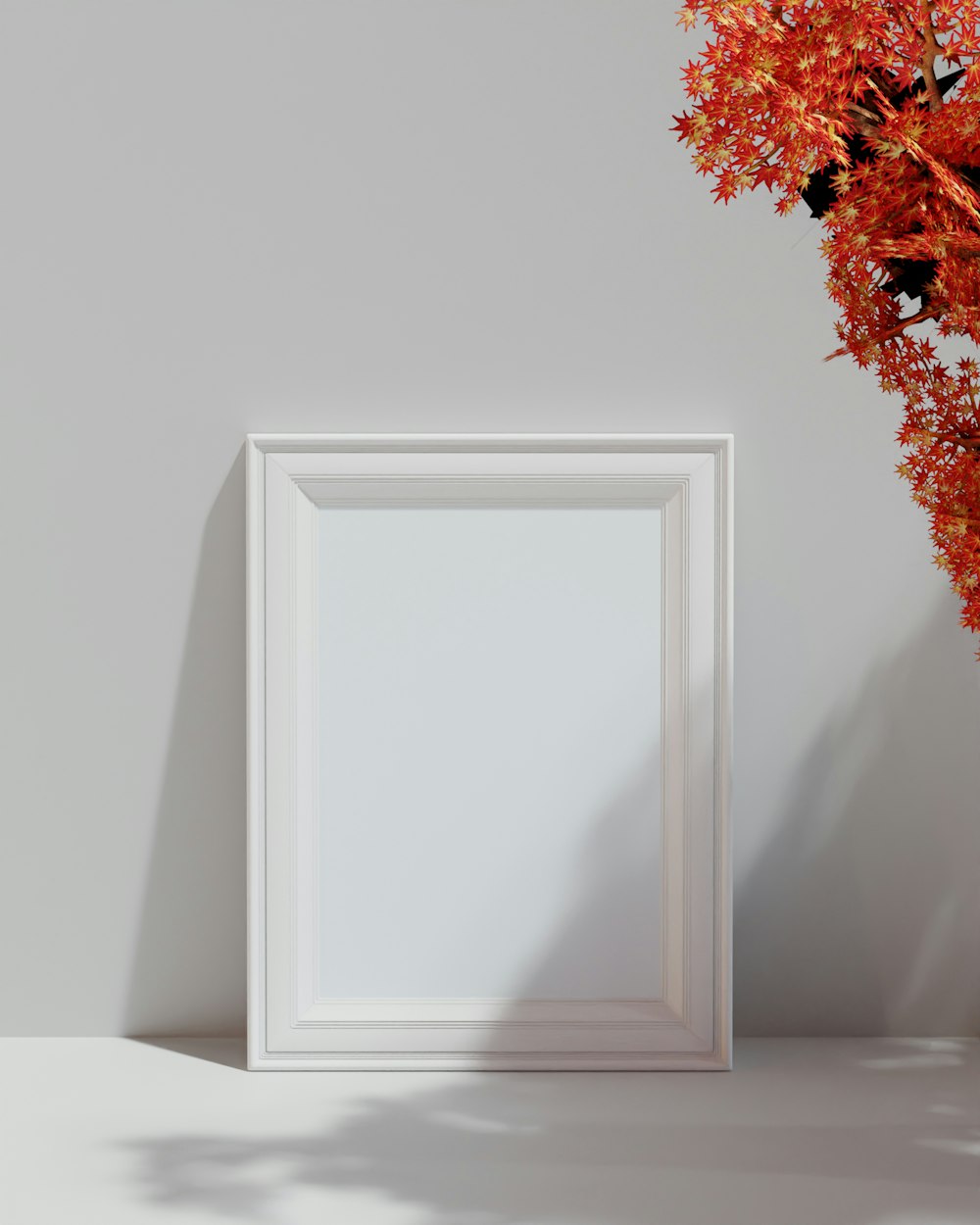 a white picture frame sitting next to a vase of flowers