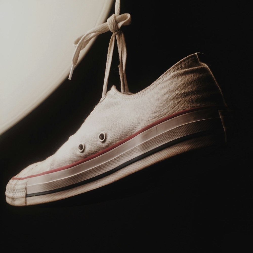 a pair of white shoes with a white shoelace