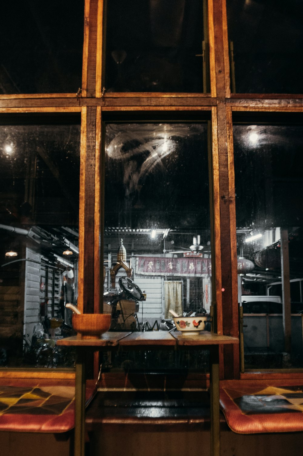 a restaurant with a large glass window and wooden benches