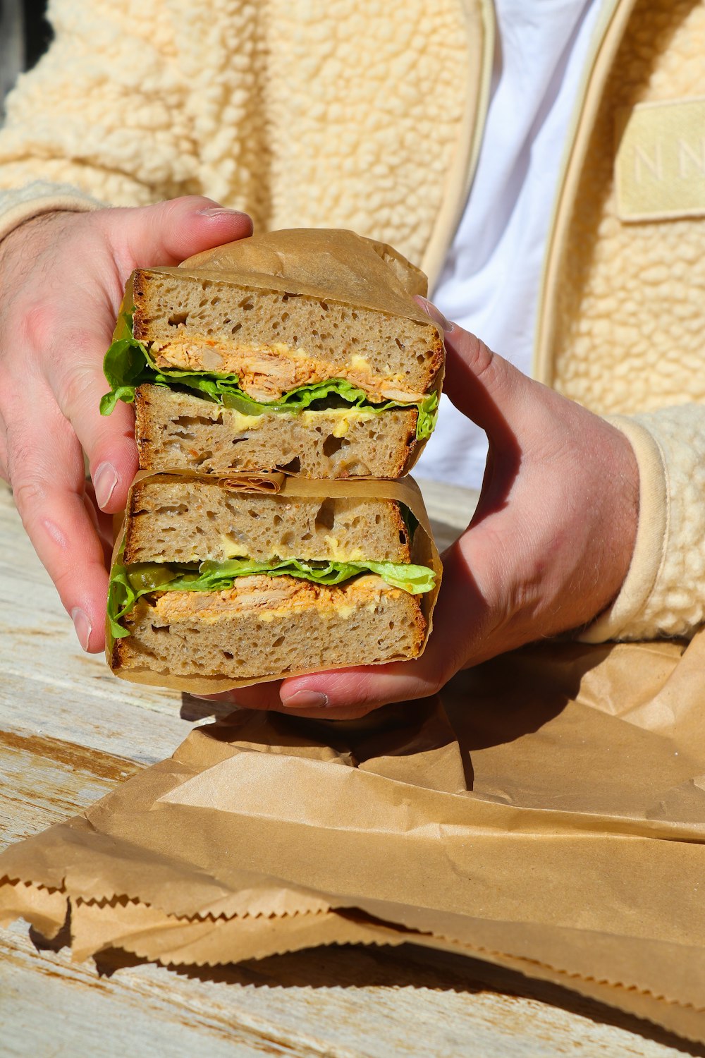 a person holding a sandwich in their hand