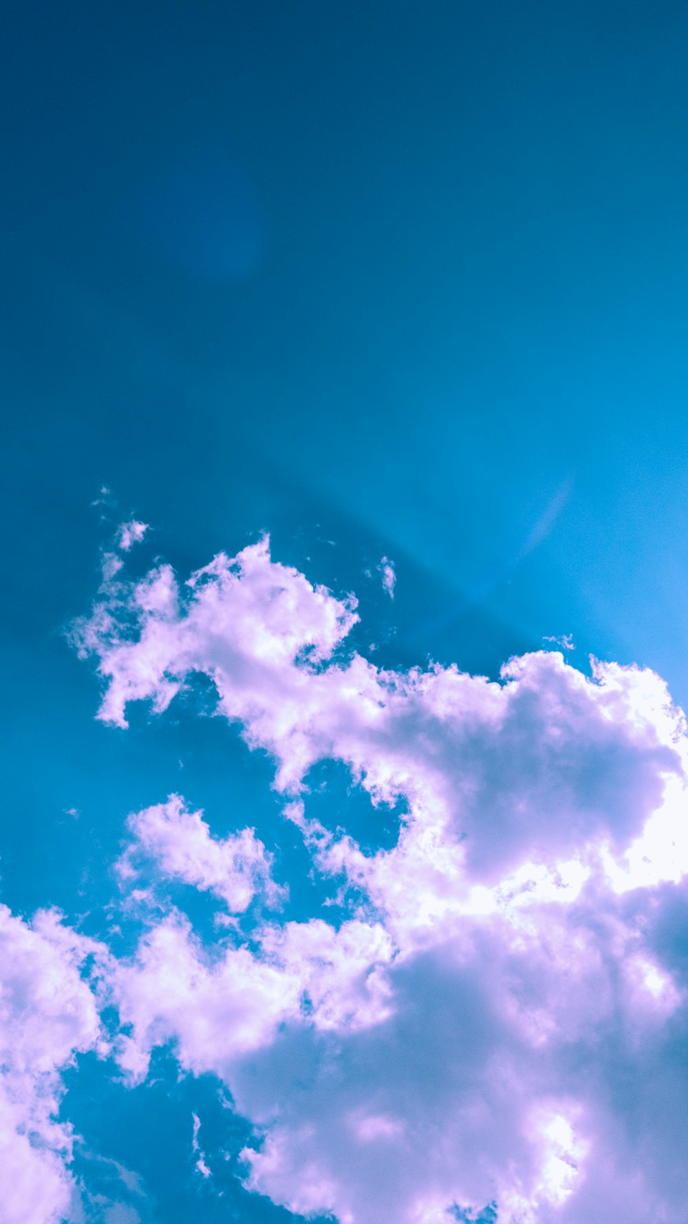 a plane flying through a blue sky with clouds