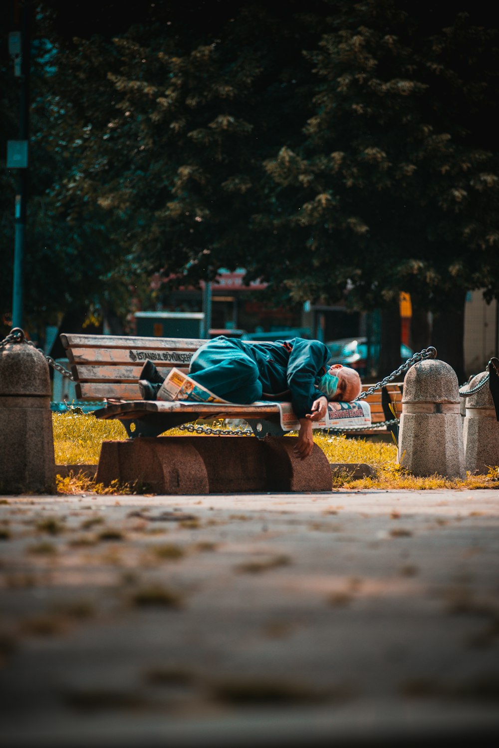 a person sleeping on a bench in a park