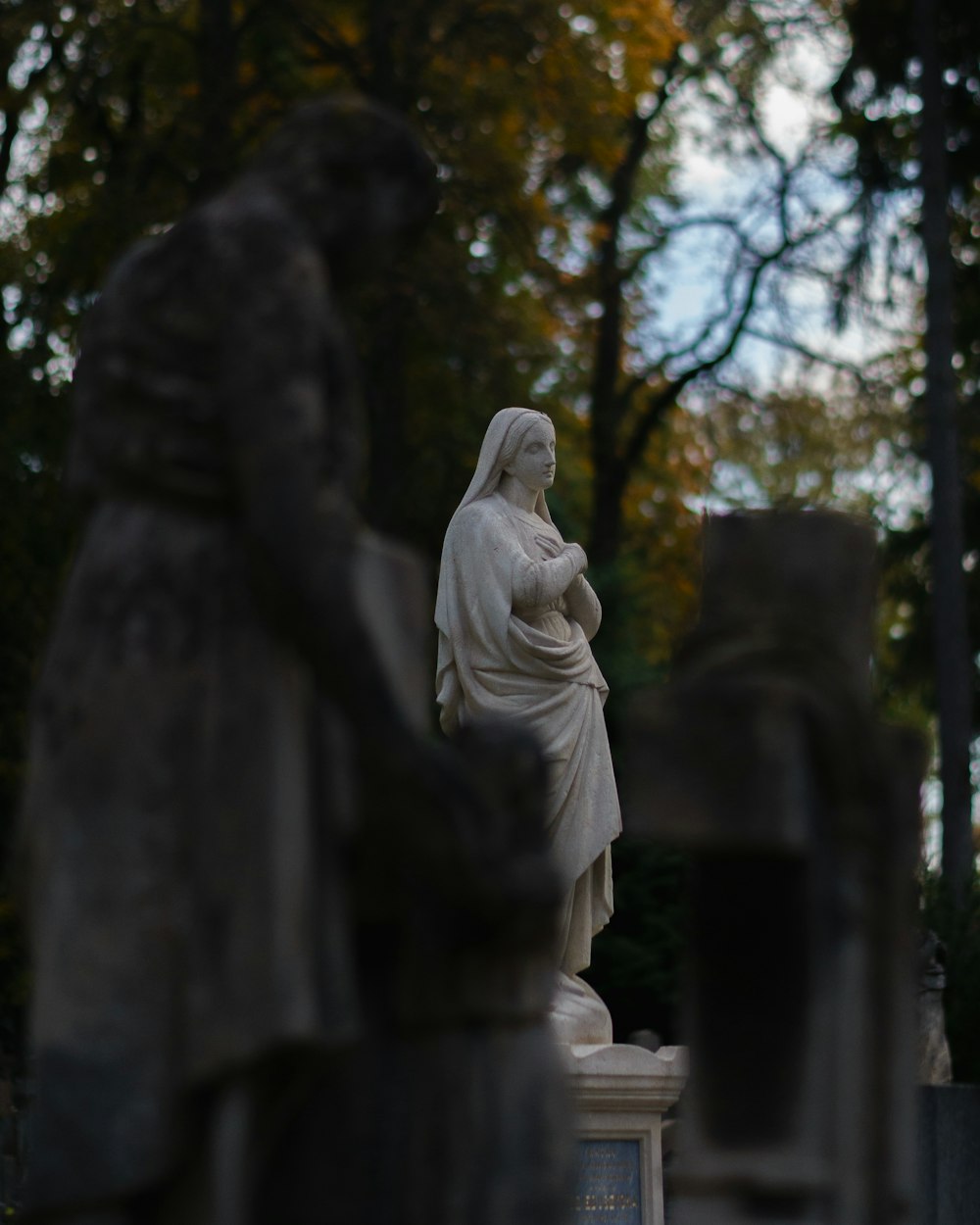 a statue of a woman standing in a cemetery