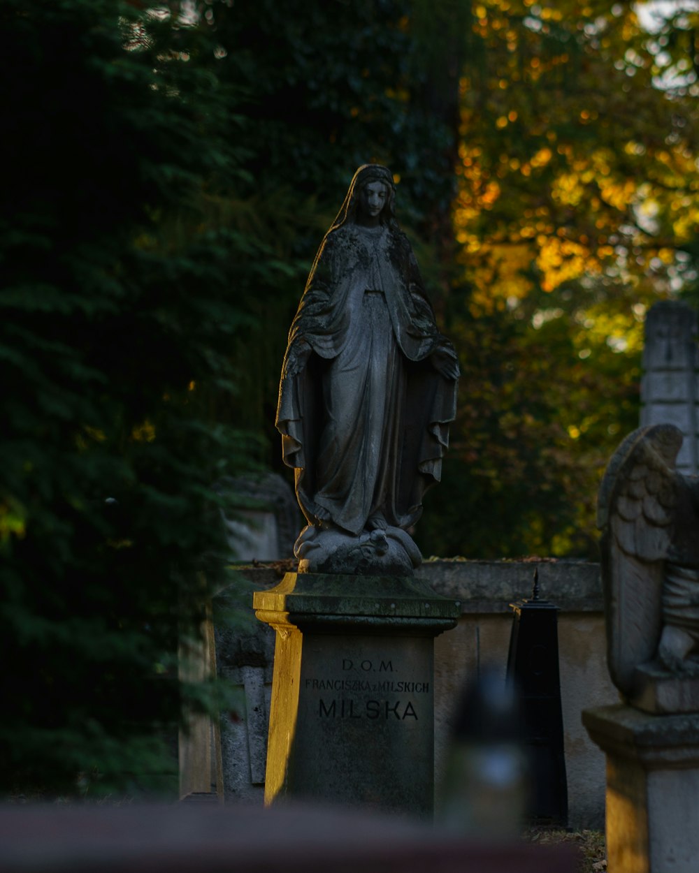 uma estátua de uma mulher em um cemitério