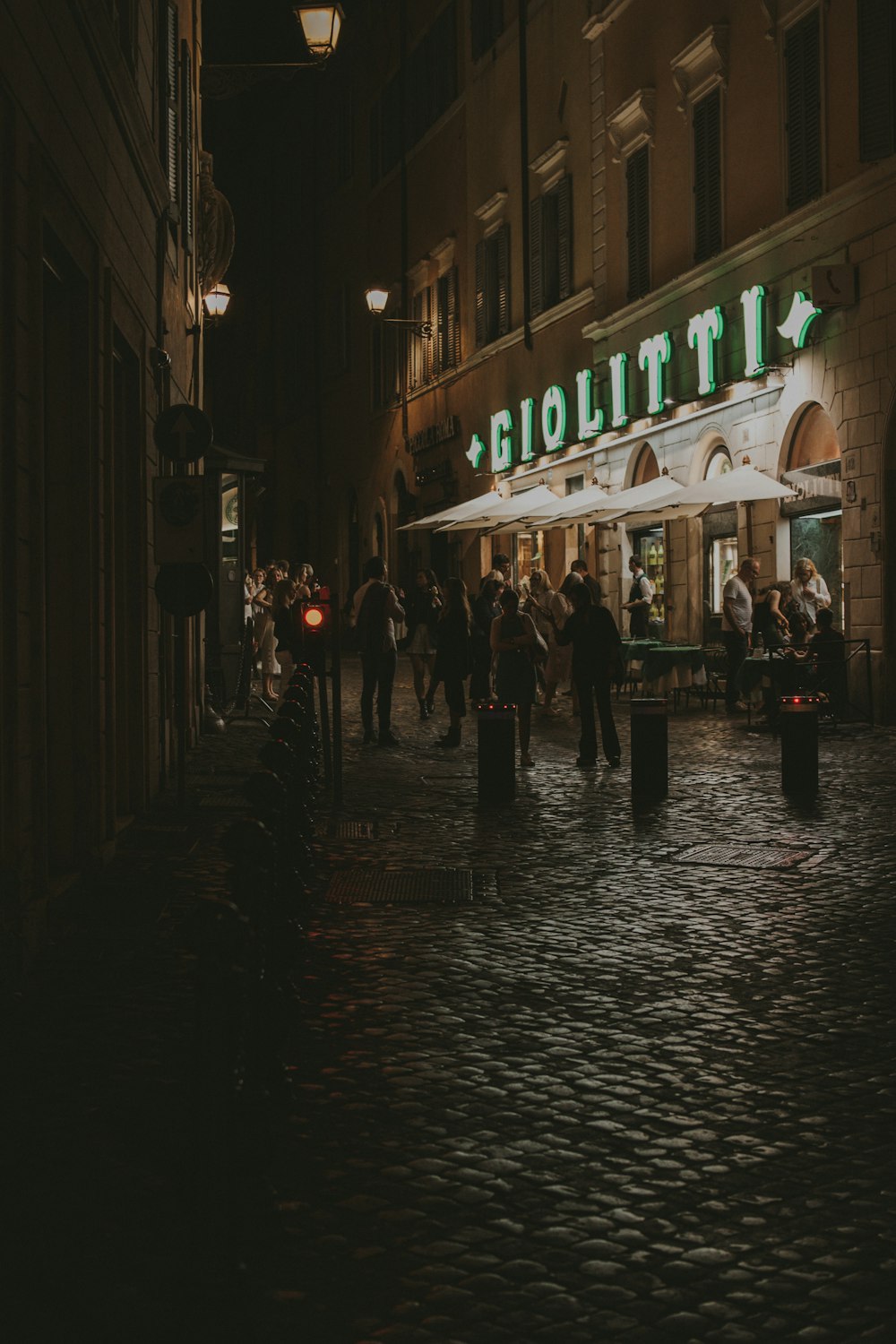 a group of people walking down a street at night