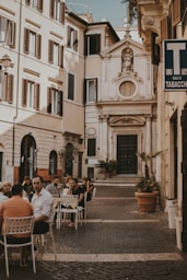 a group of people sitting at a table outside of a building