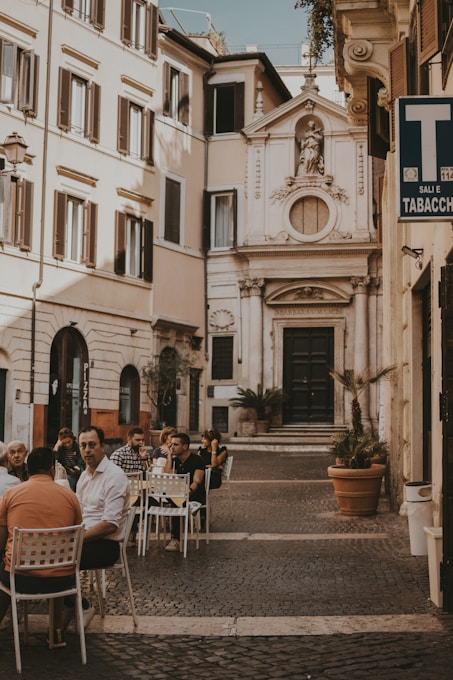 a group of people sitting at a table outside of a building