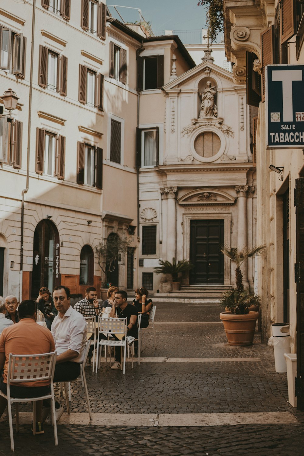 a group of people sitting at a table outside of a building