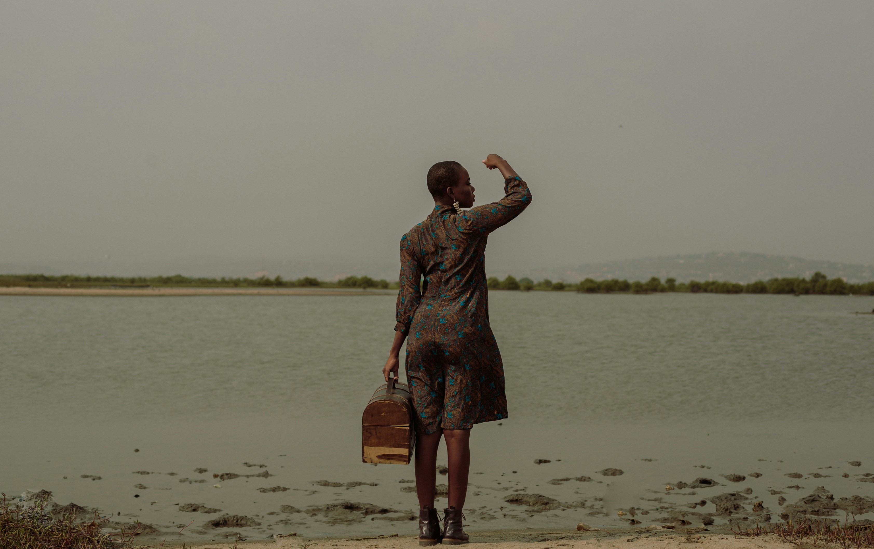 a person standing on a beach with a suitcase