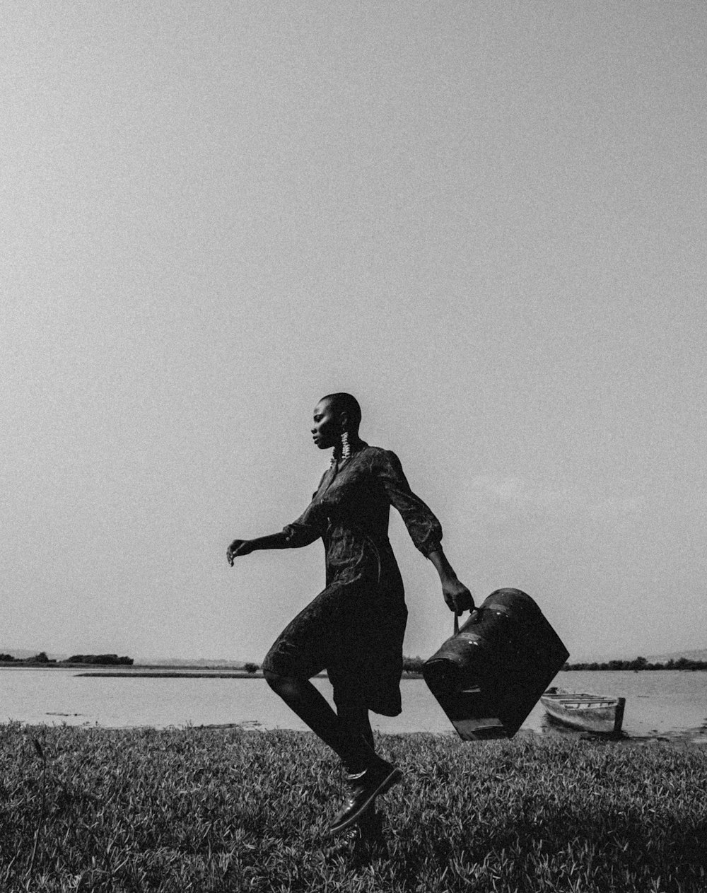 a man with a suit case walking across a field