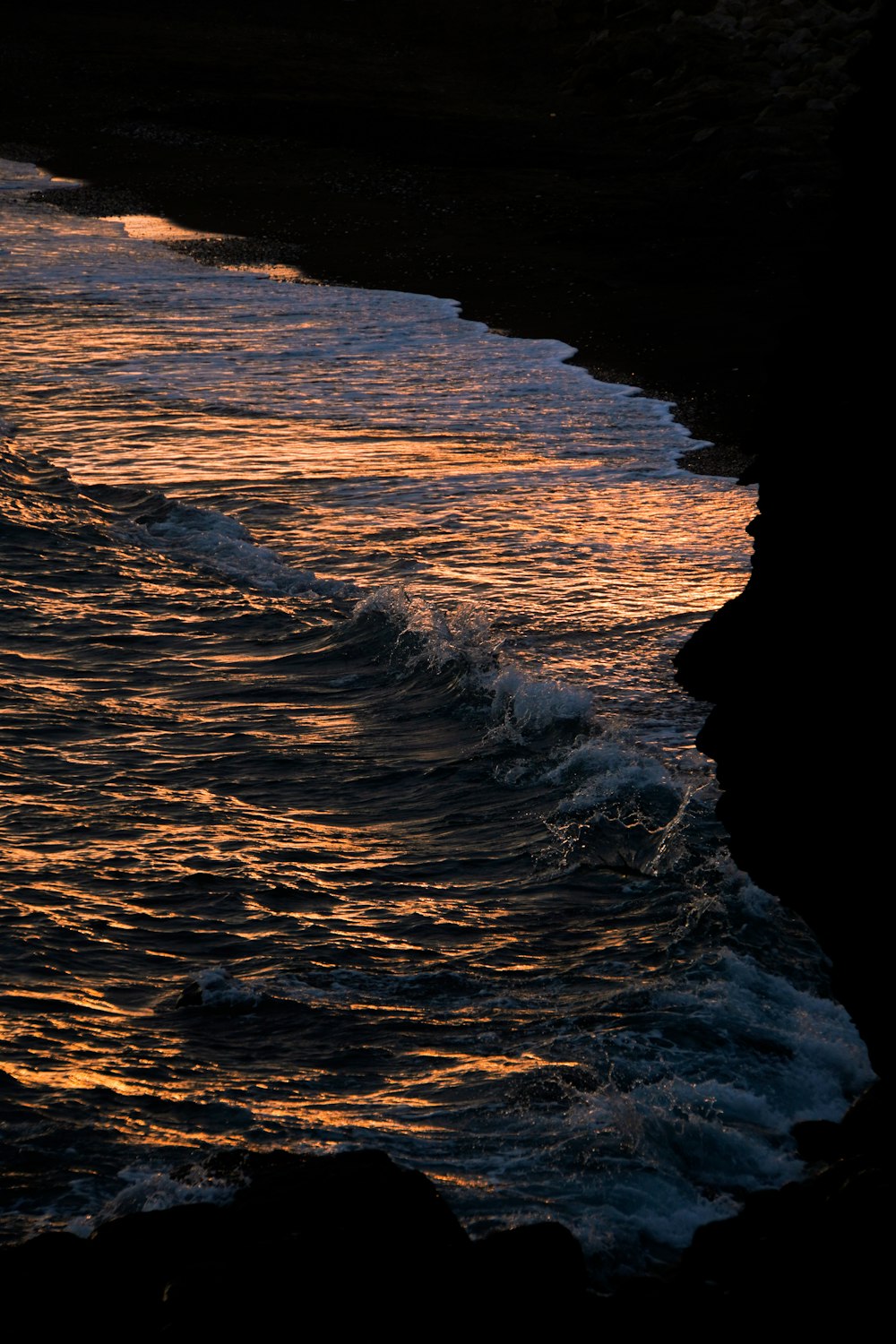 the sun is setting over the ocean with waves