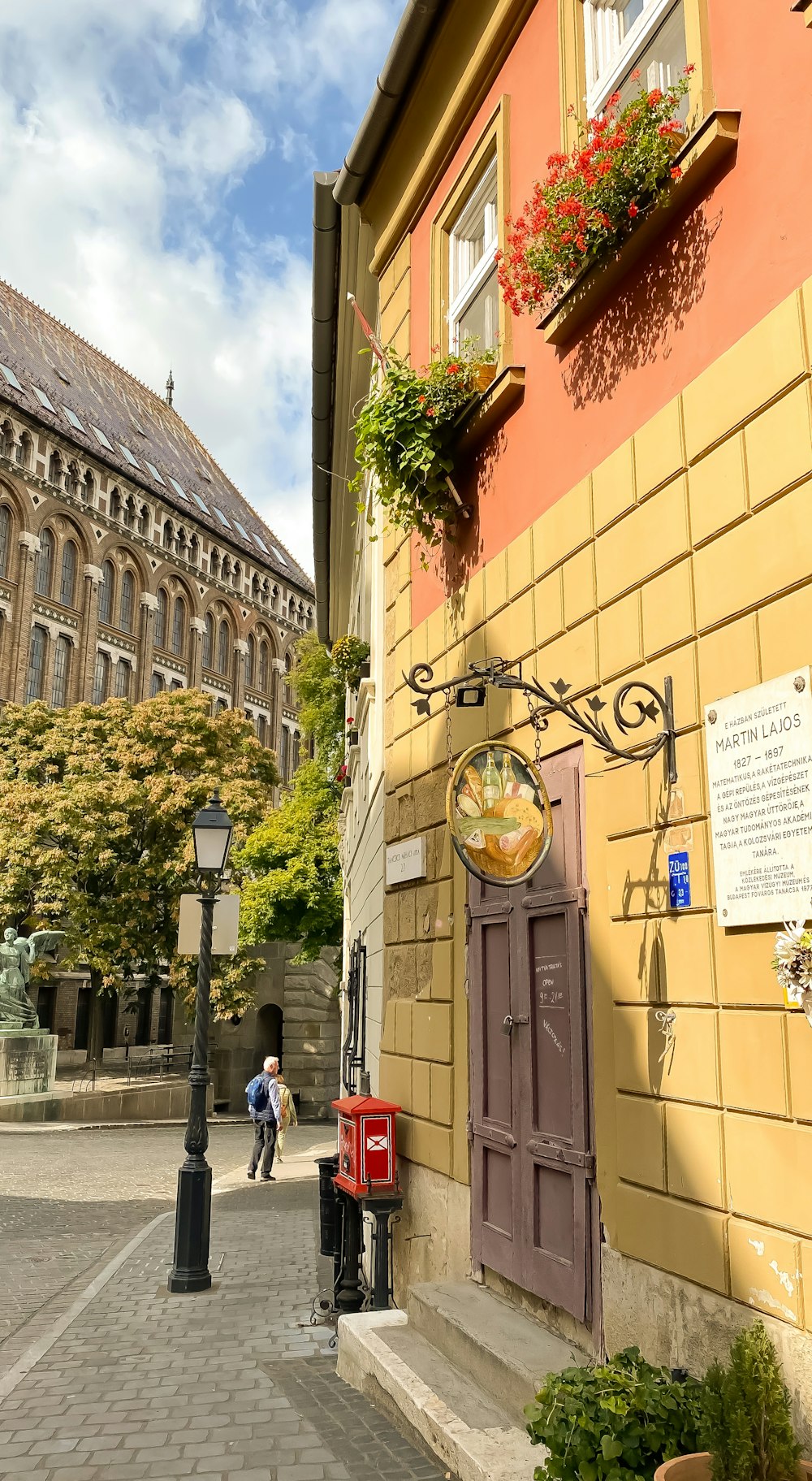 a couple of people walking down a street next to a building