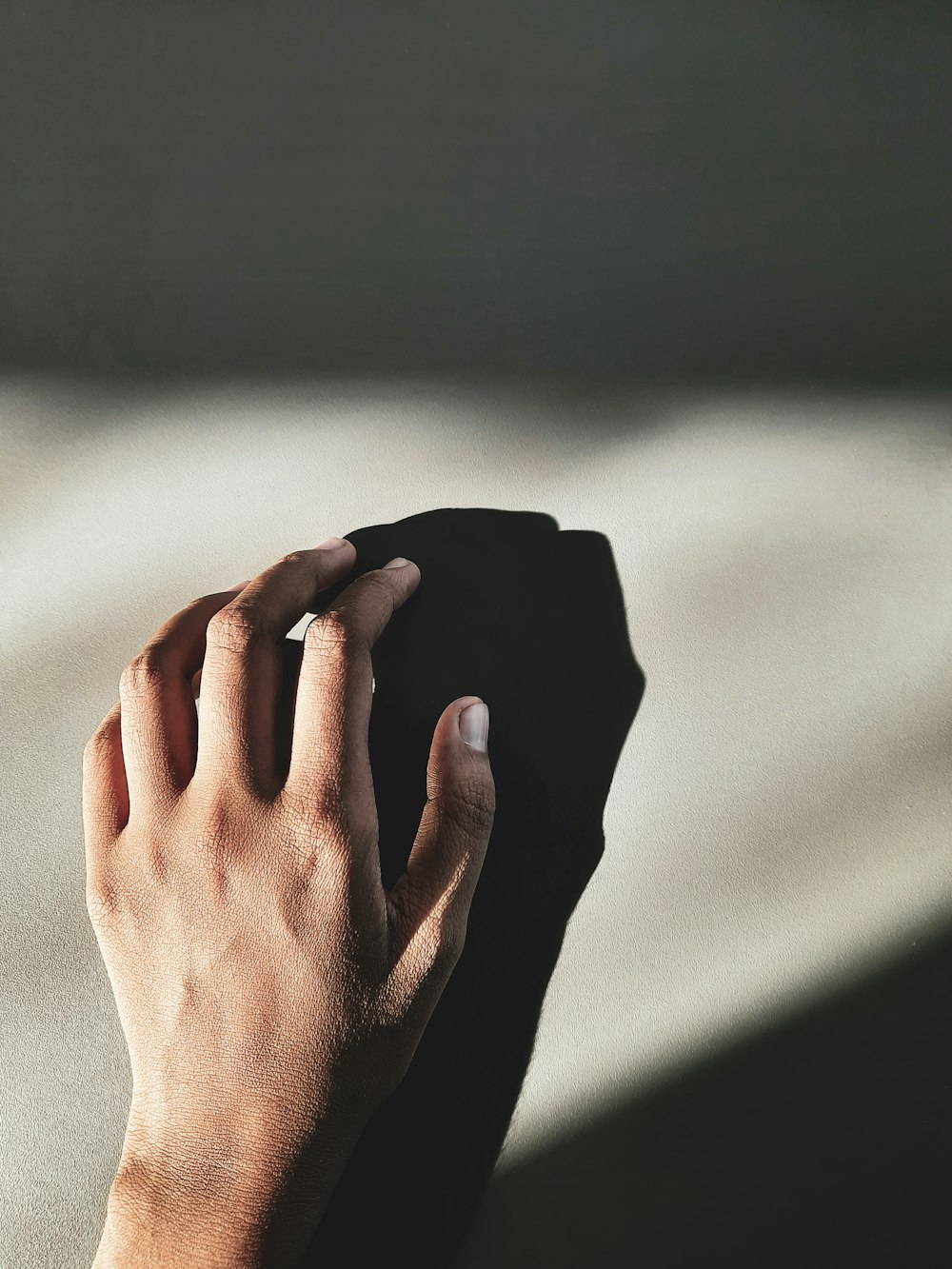 a person's hand on top of a black object