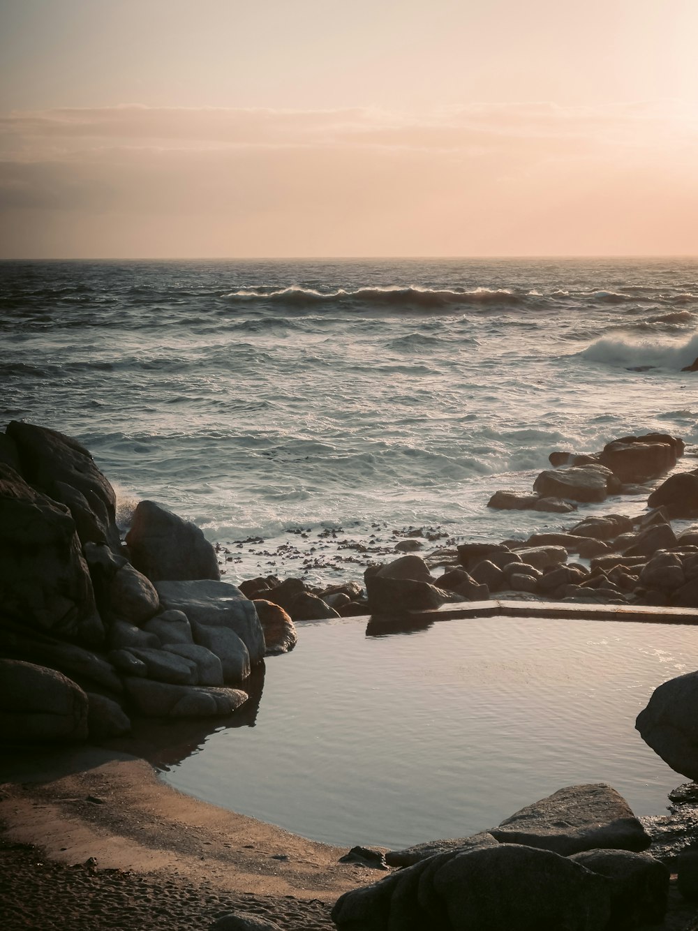 a body of water sitting next to a rocky shore