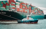 a tug boat pulling a large container ship