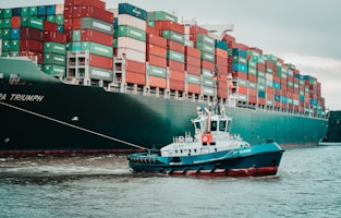 a tug boat pulling a large container ship