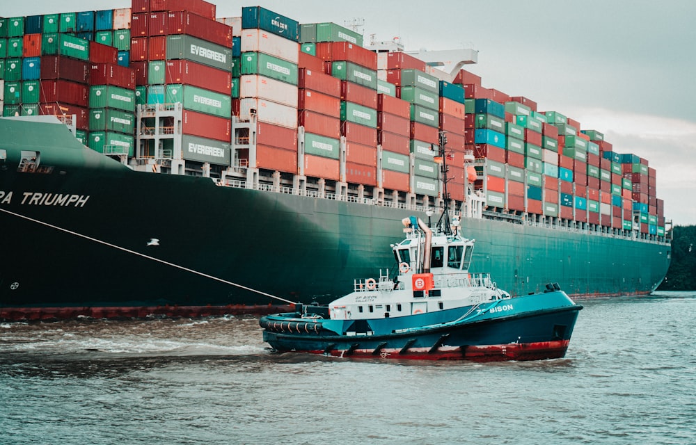 Ein Schlepper, der ein großes Containerschiff zieht