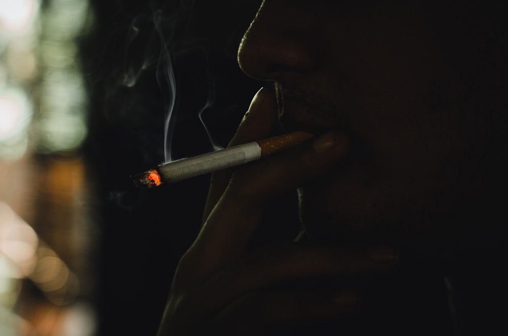 a man smoking a cigarette in the dark