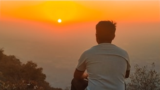 A traveler gazing at a sunset over a vast landscape, symbolizing exploration and discovery.