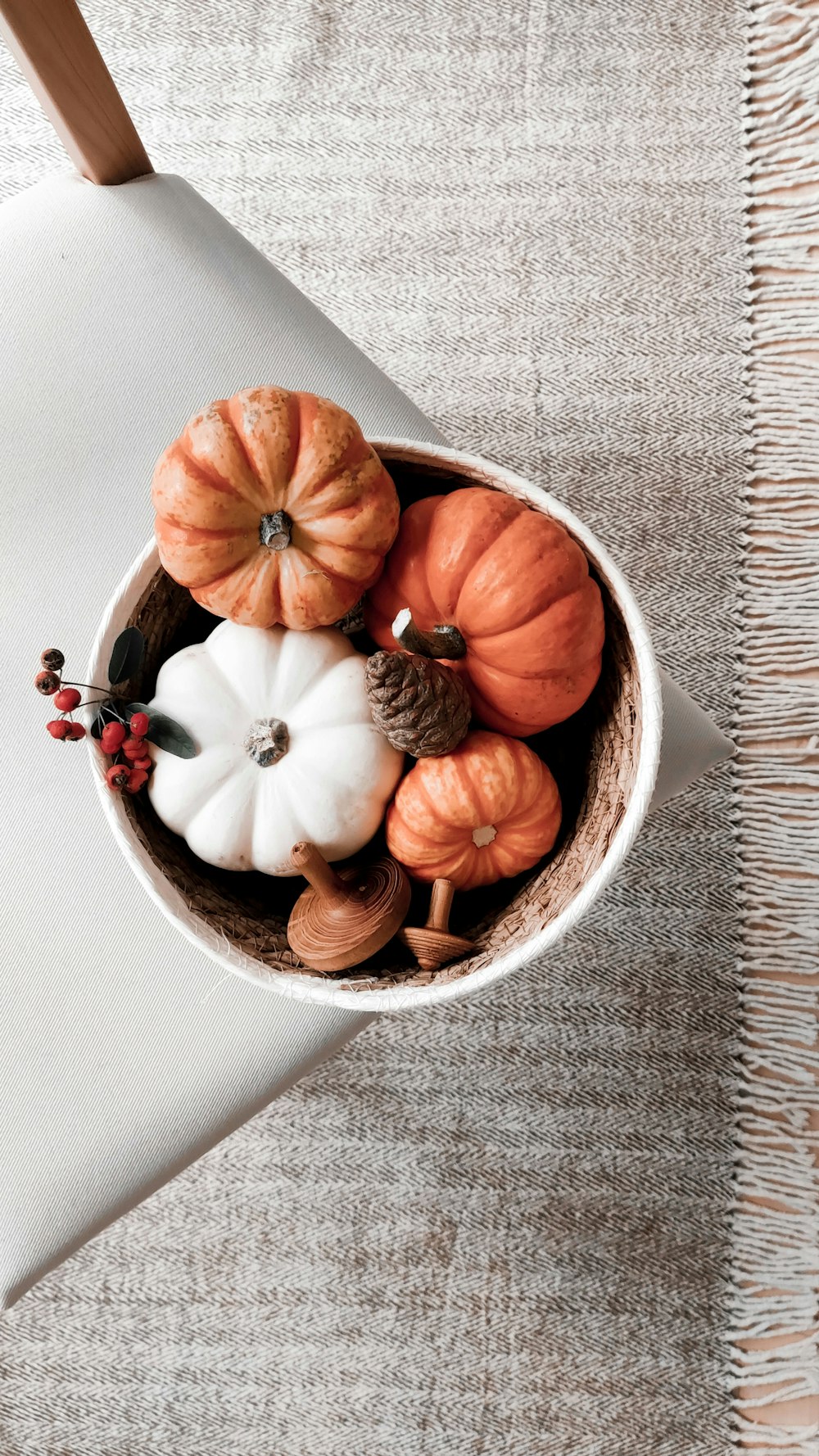 a bowl filled with fake pumpkins on top of a table