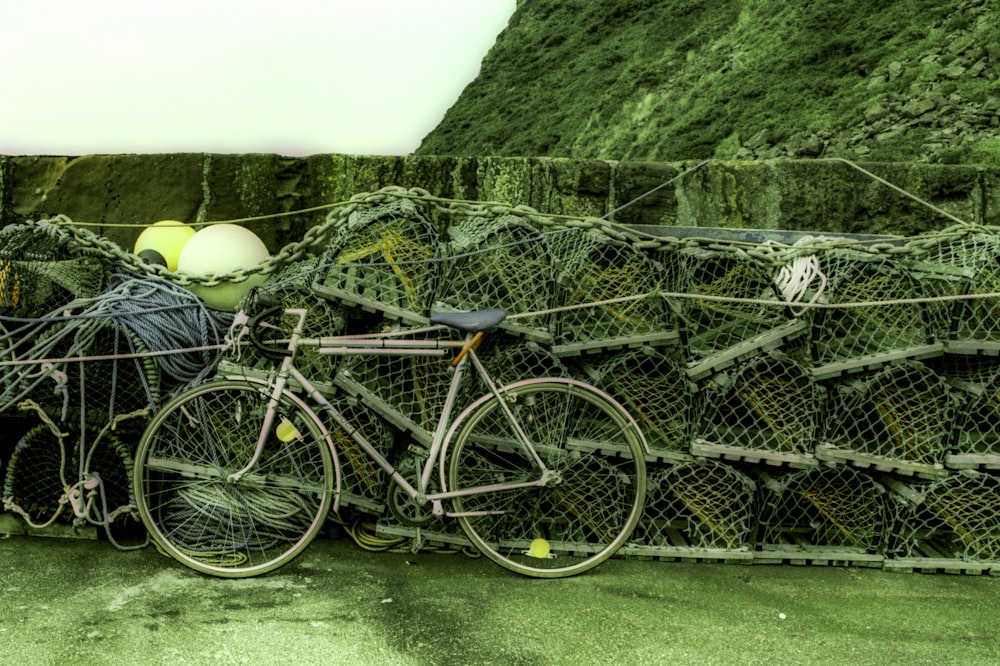 a bicycle parked next to a pile of fishing nets