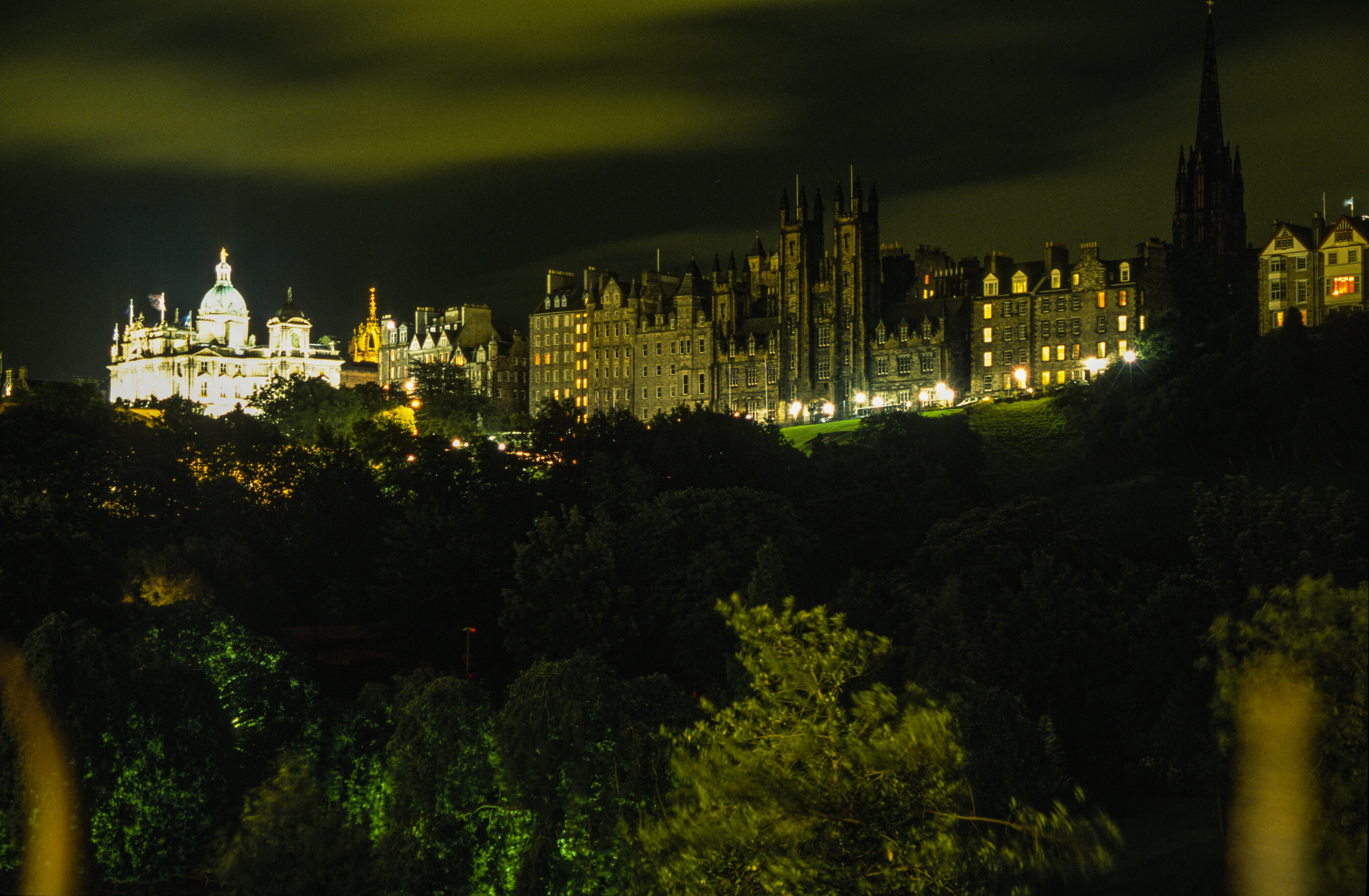 a night view of a city with a castle in the background