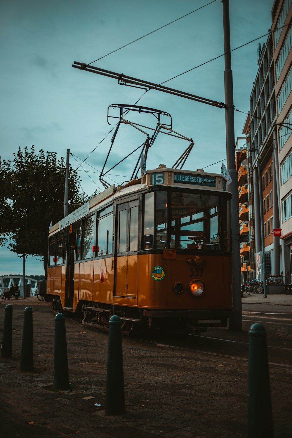 an orange trolley car on a city street