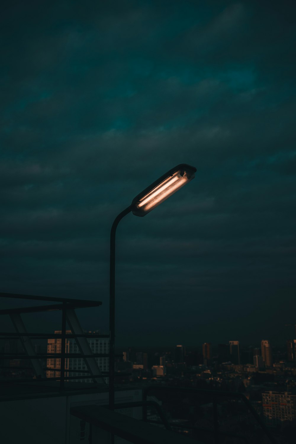 a street light in the dark with a city in the background