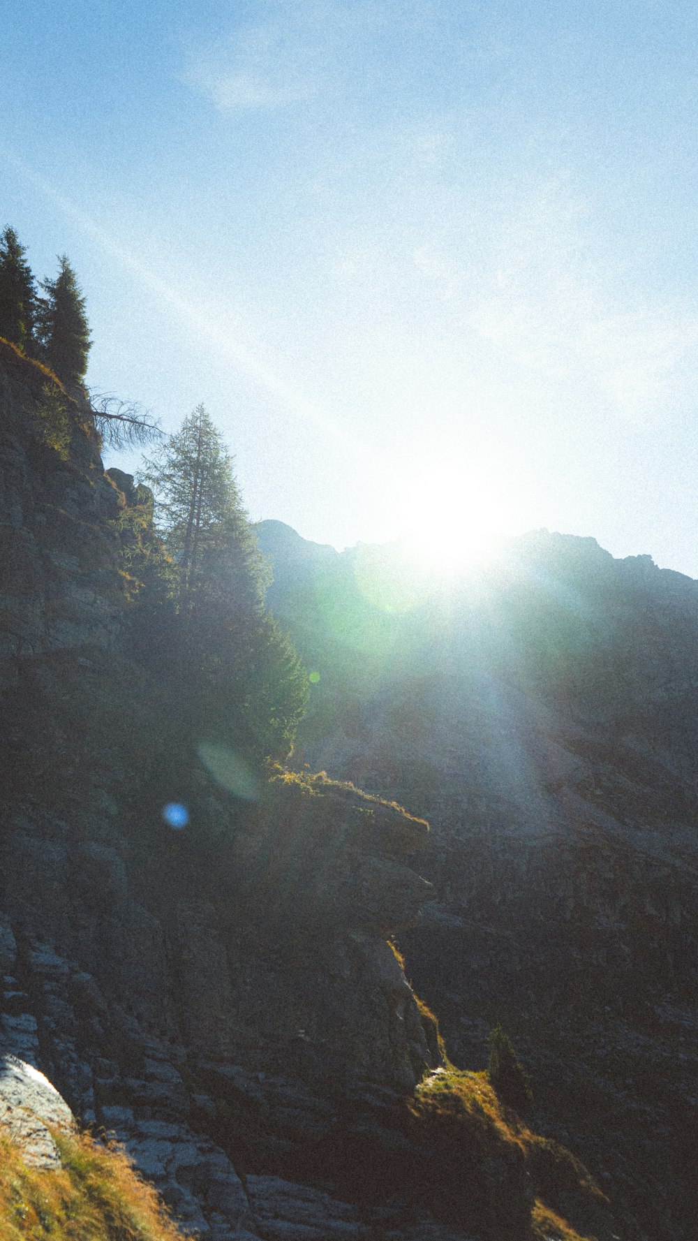 the sun shines brightly on a rocky cliff