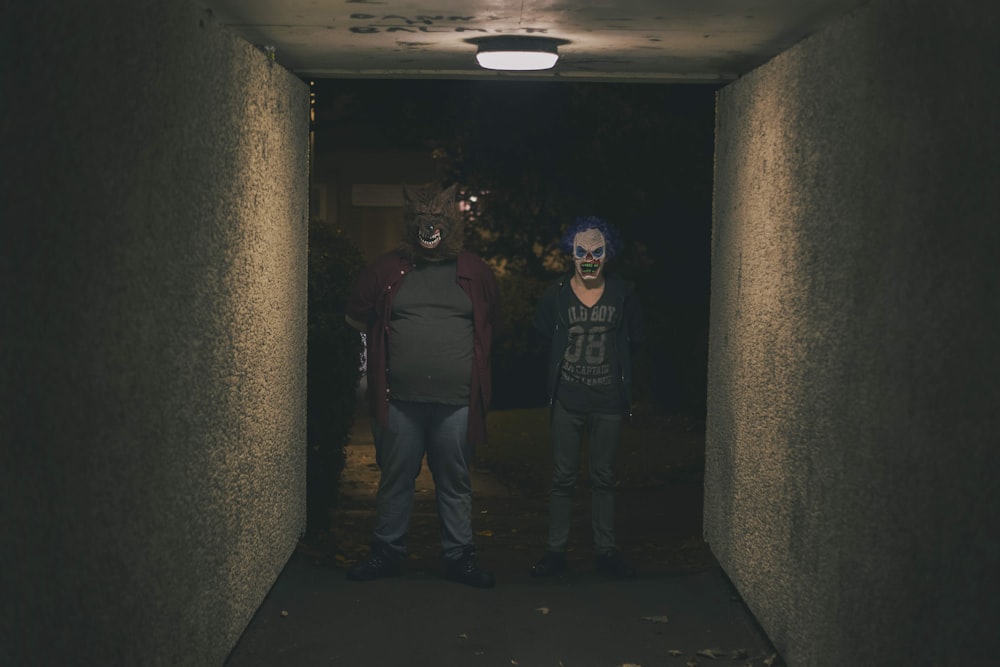 a couple of people that are standing in a hallway