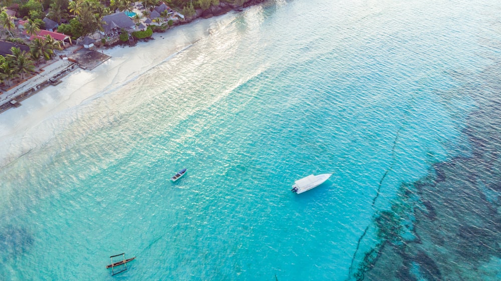 an aerial view of a beach with a boat in the water