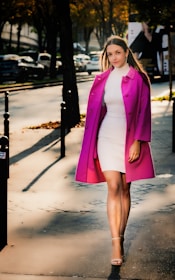 Lifestyle shot of a woman walking through sunlit streets wearing a soft peach ensemble.