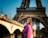 a woman standing in front of the eiffel tower