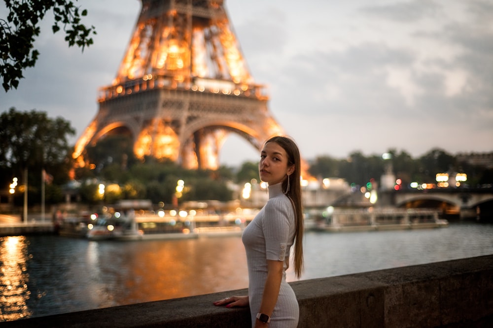 a woman standing in front of the eiffel tower