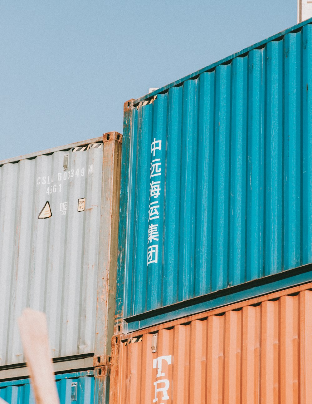 a person standing in front of a stack of shipping containers