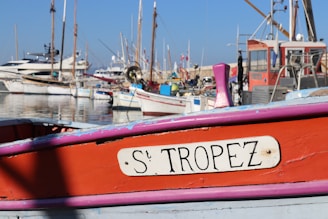 a red and pink boat sitting in the water