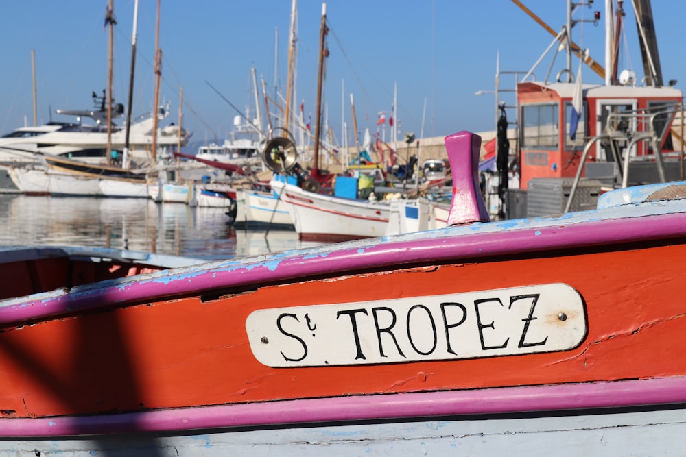 a red and pink boat sitting in the water