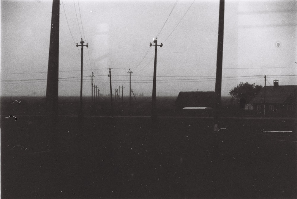 a black and white photo of telephone poles and houses