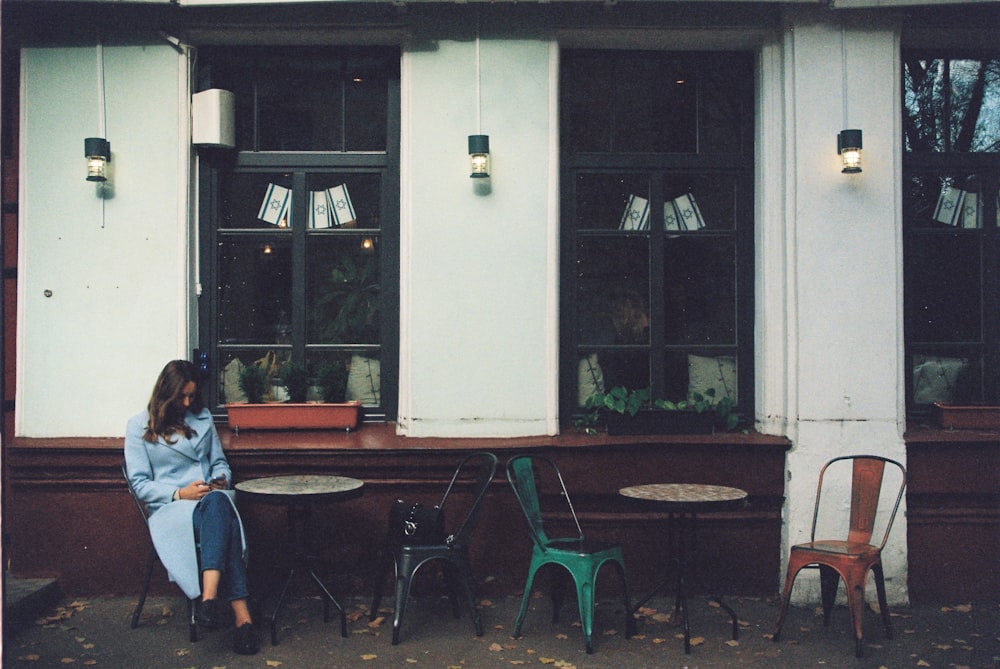 a woman sitting at a table in front of a window