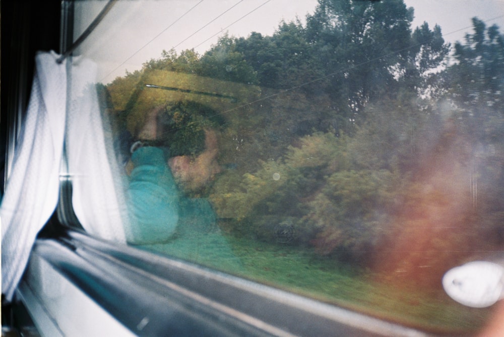 a woman taking a picture out of a window