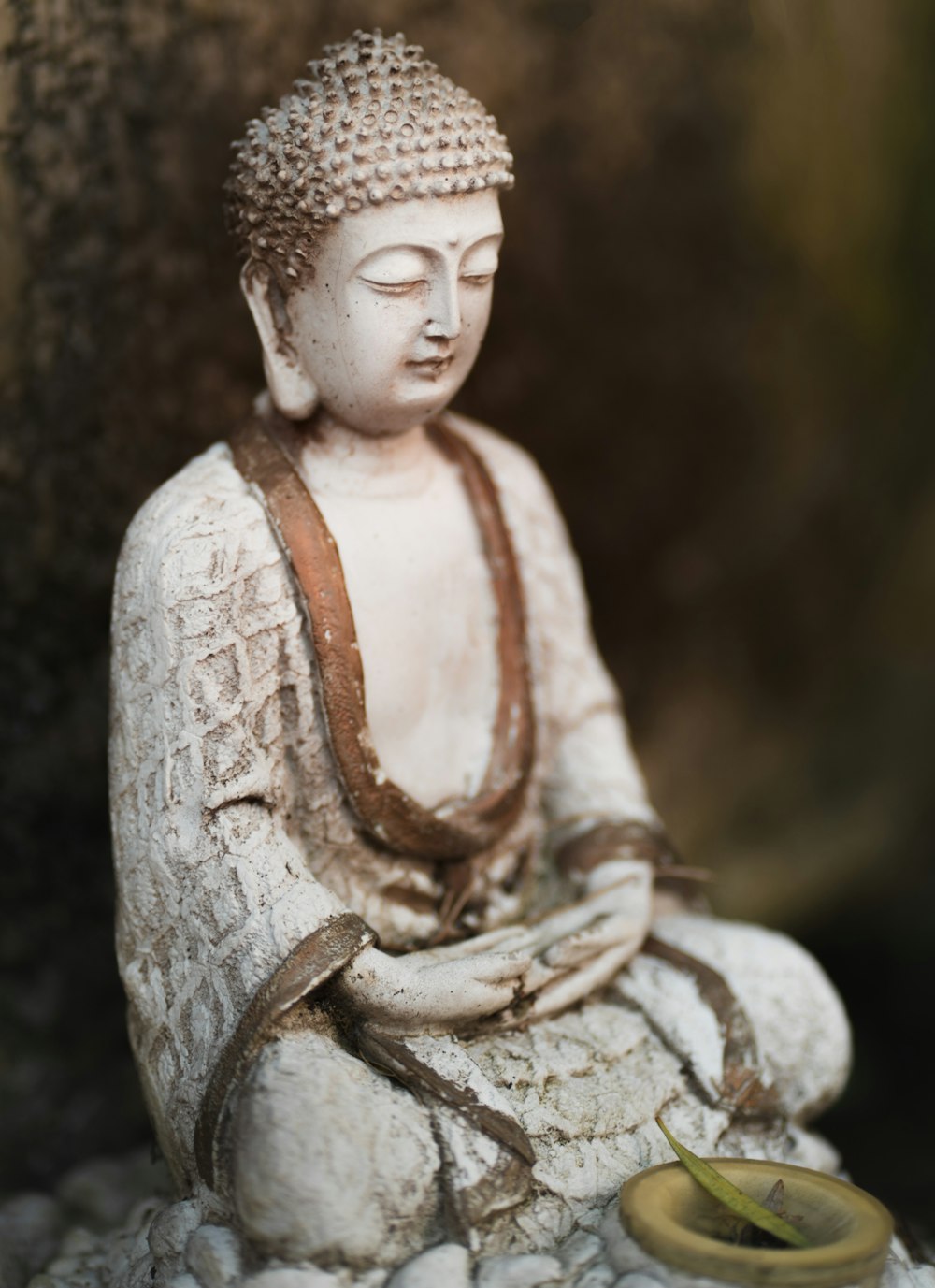 a buddha statue sitting on top of a pile of rocks