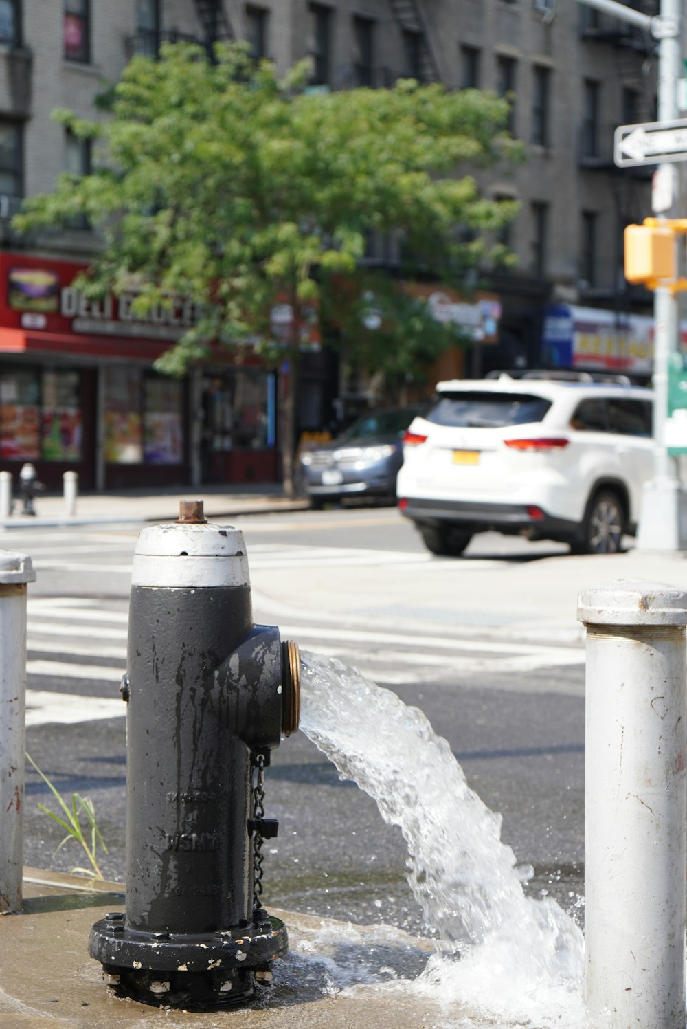 a fire hydrant spewing water on a city street