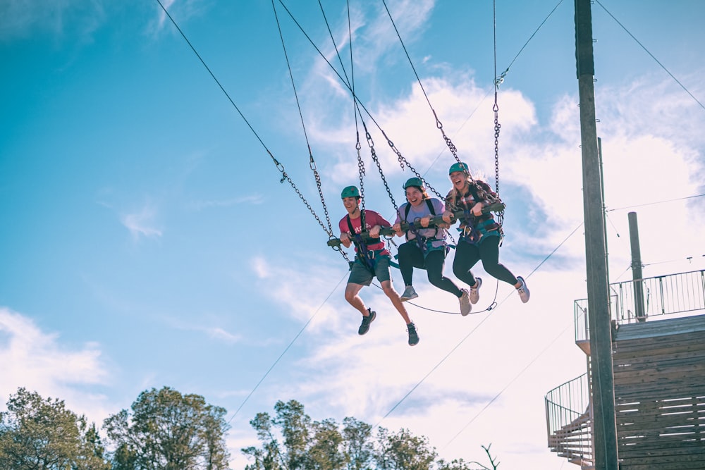 a group of people riding zip lines in the air