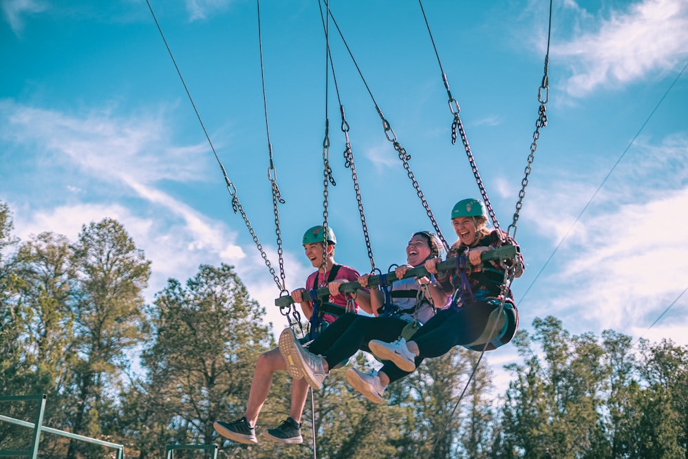 a group of people riding on top of a zip line