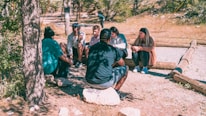 a group of people sitting around a tree