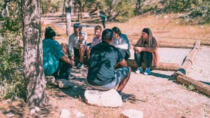 a group of people sitting around a tree