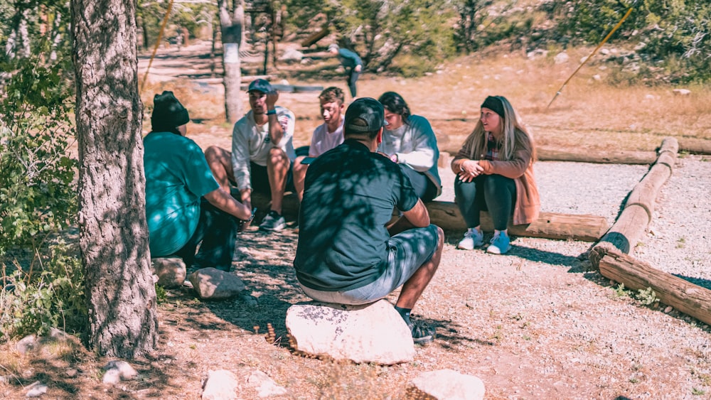 a group of people sitting around a tree
