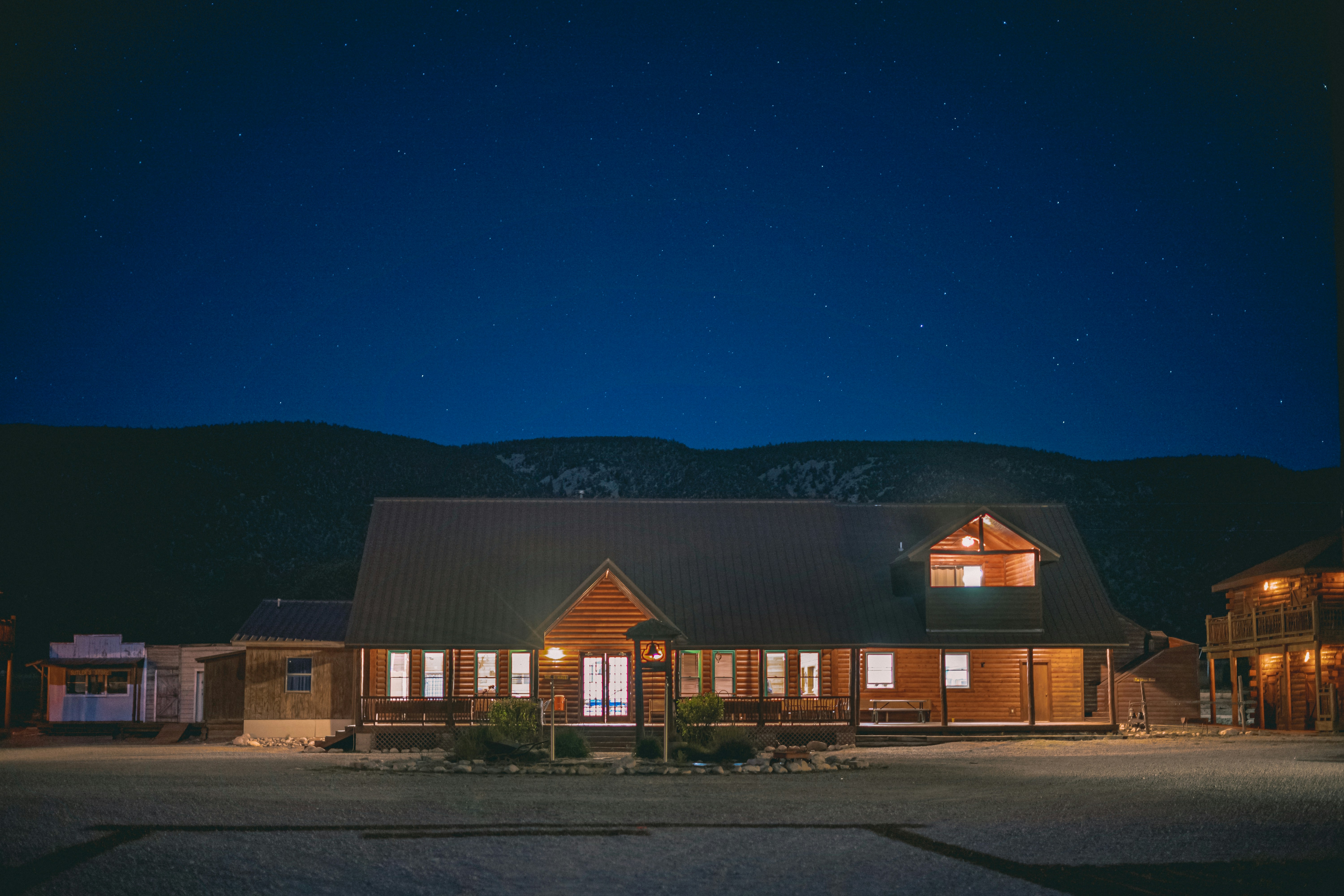 a house lit up at night with mountains in the background